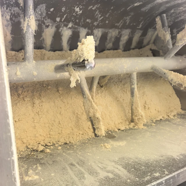 Close view of small dough clumps adhering to the vacuum mixer bars